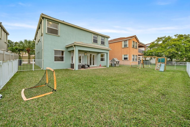 back of house with a yard, a patio, and a playground