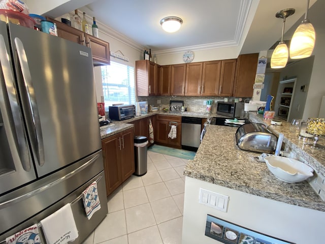 kitchen with light stone counters, decorative light fixtures, ornamental molding, and stainless steel appliances