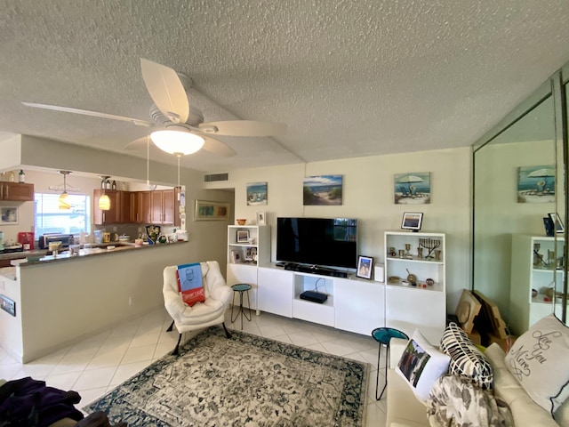 tiled living room with ceiling fan and a textured ceiling