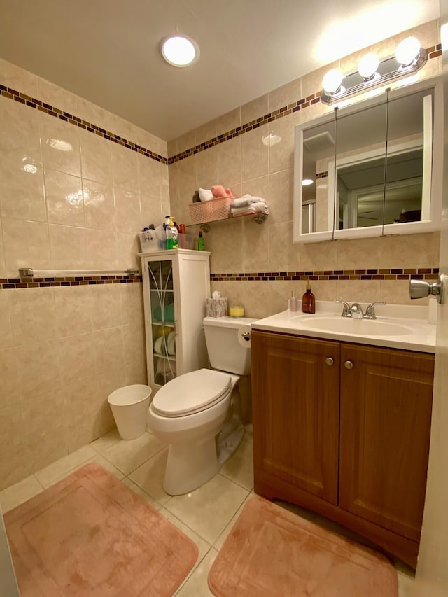 bathroom featuring tile walls, vanity, tile patterned floors, and toilet