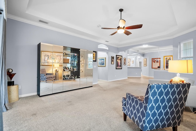 sitting room with crown molding, carpet floors, ceiling fan, and a tray ceiling