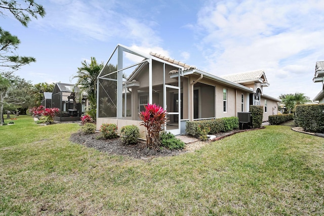 back of house with a yard and a lanai