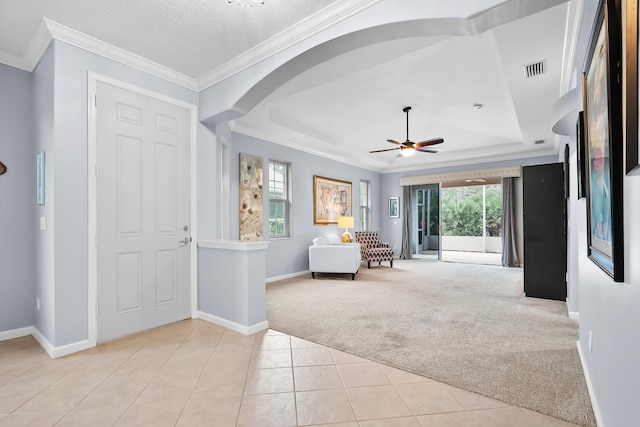 carpeted entrance foyer with ornamental molding, a textured ceiling, and ceiling fan