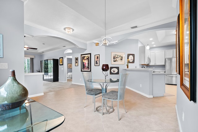 tiled dining room featuring crown molding, a raised ceiling, and ceiling fan