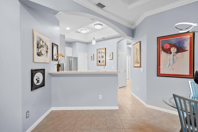 corridor with crown molding, a raised ceiling, and light tile patterned floors