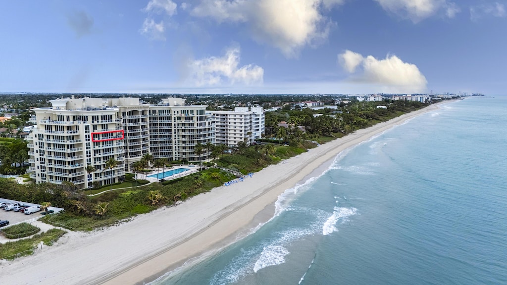 birds eye view of property featuring a water view and a beach view