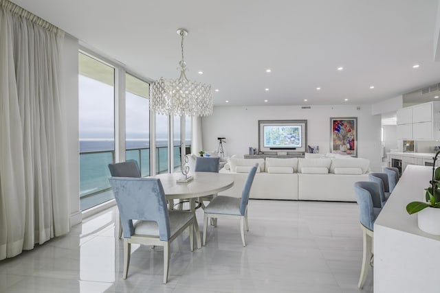 dining area with a notable chandelier, a wealth of natural light, expansive windows, and a water view