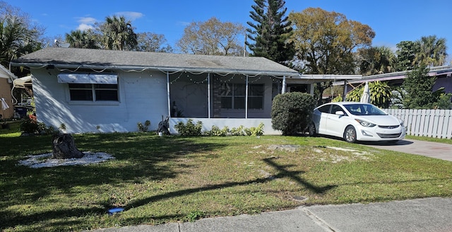 view of front facade with a front lawn and a sunroom