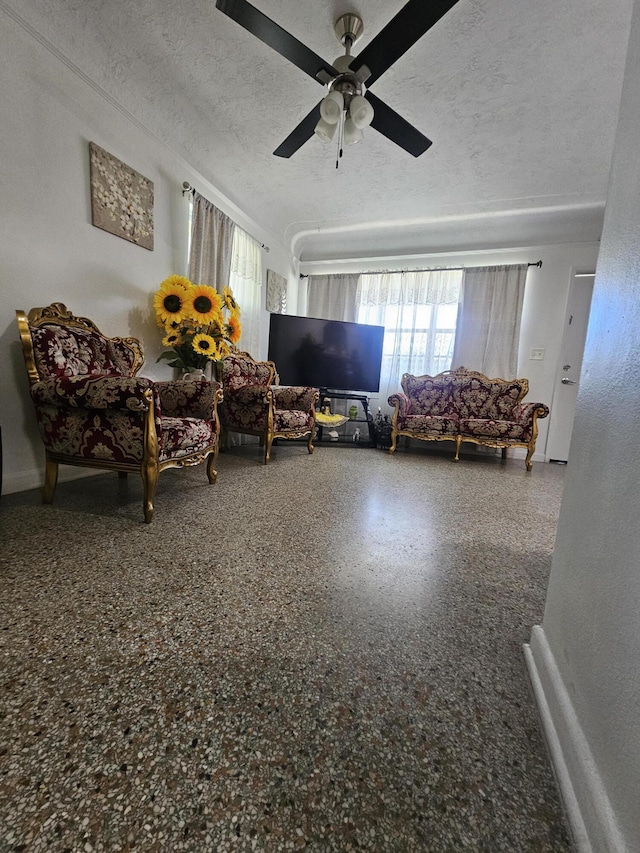 living room featuring ceiling fan and a textured ceiling