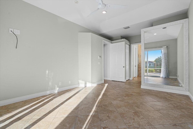 tiled spare room with ceiling fan