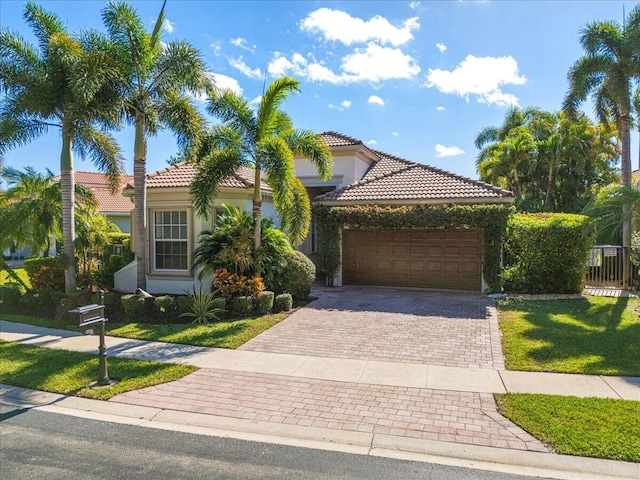 mediterranean / spanish home with a garage and a front lawn