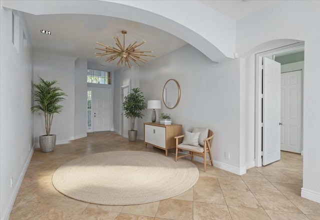 tiled entrance foyer with a notable chandelier