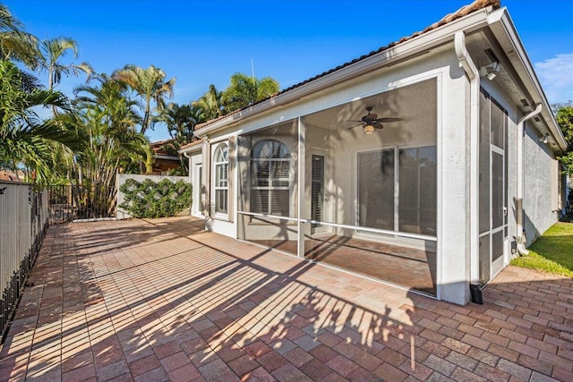 exterior space featuring a sunroom, ceiling fan, and a patio area