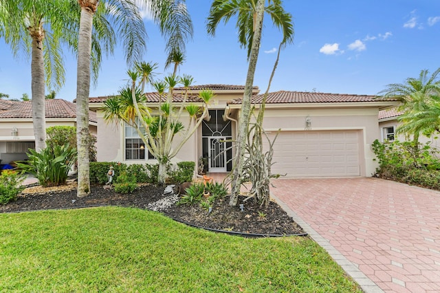 mediterranean / spanish house with a garage and a front lawn