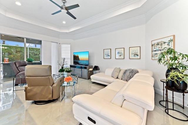 living room with a tray ceiling, ornamental molding, and ceiling fan