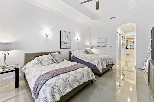 bedroom with ceiling fan, ensuite bath, crown molding, and a raised ceiling