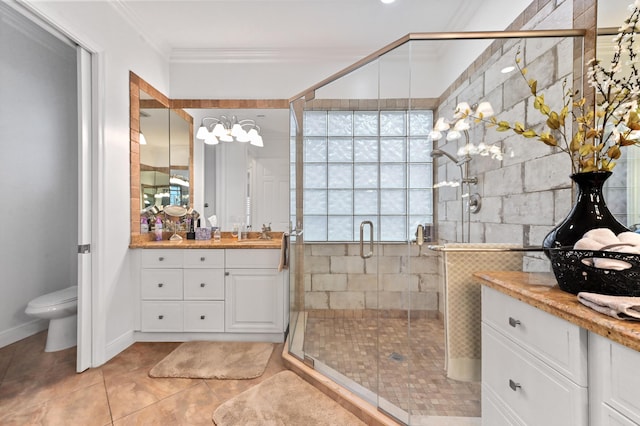 bathroom with tile patterned floors, ornamental molding, a shower with shower door, and vanity