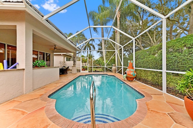 view of swimming pool with a patio, a lanai, and ceiling fan