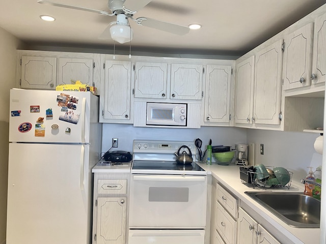 kitchen featuring white cabinetry, sink, ceiling fan, and white appliances