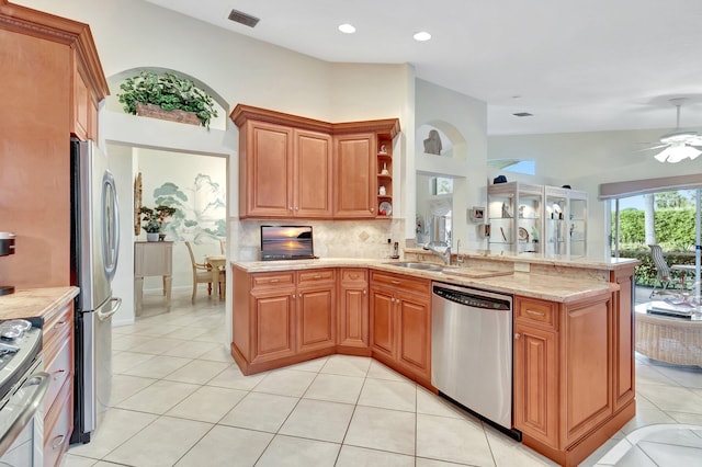 kitchen with visible vents, a peninsula, a sink, appliances with stainless steel finishes, and brown cabinets