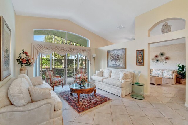 living room featuring light tile patterned floors, high vaulted ceiling, and a chandelier