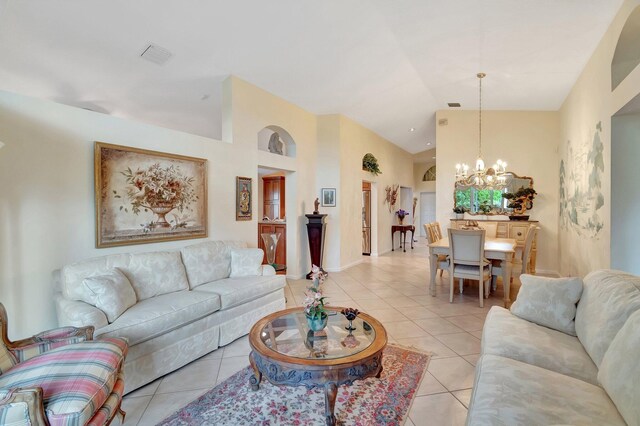 tiled living room with high vaulted ceiling and an inviting chandelier