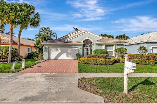 mediterranean / spanish home featuring a garage and a front lawn