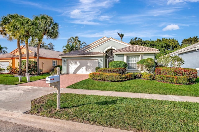 view of front of property featuring a front lawn, a tile roof, stucco siding, decorative driveway, and an attached garage