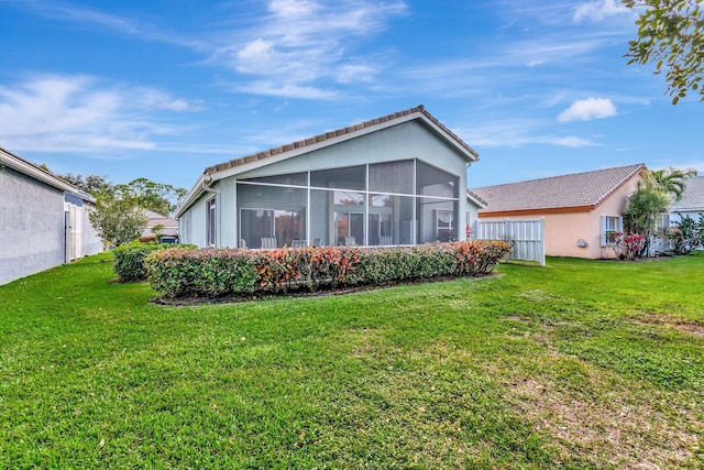 back of property with a sunroom and a yard