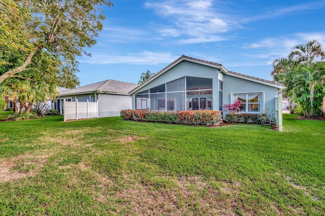 back of property with a yard and a sunroom