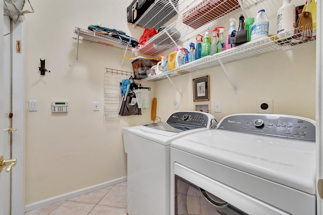 washroom with separate washer and dryer and light tile patterned floors