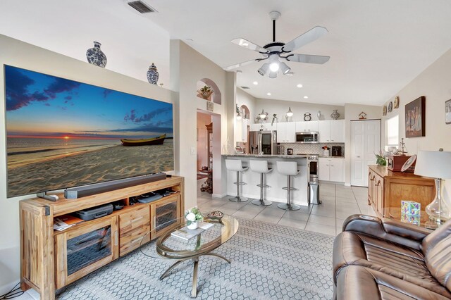 kitchen featuring light tile patterned floors, appliances with stainless steel finishes, light stone countertops, white cabinets, and kitchen peninsula