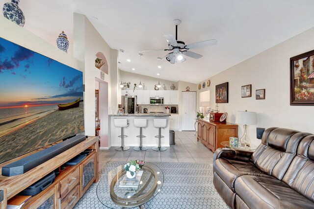 kitchen with light stone counters, stainless steel appliances, light tile patterned floors, and white cabinets