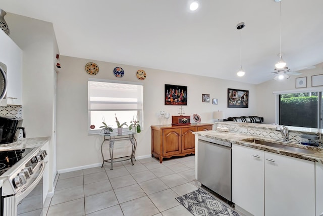 kitchen with sink, hanging light fixtures, appliances with stainless steel finishes, light stone countertops, and white cabinets