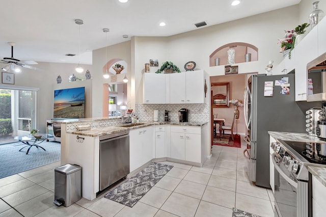 kitchen with visible vents, backsplash, appliances with stainless steel finishes, a peninsula, and white cabinetry