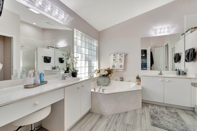 bathroom with lofted ceiling, independent shower and bath, and vanity