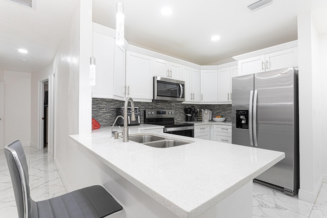 kitchen featuring white cabinetry, appliances with stainless steel finishes, decorative backsplash, and kitchen peninsula