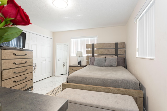 bedroom with a textured ceiling and a closet