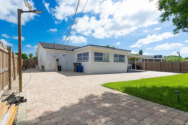 back of house with a patio area and a lawn