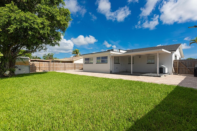 rear view of property featuring a yard and a patio