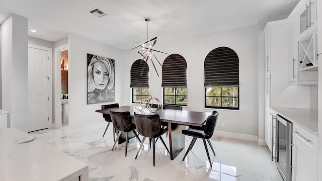 dining space with an inviting chandelier and beverage cooler