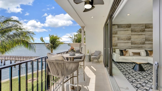 balcony featuring an outdoor living space, a water view, and ceiling fan