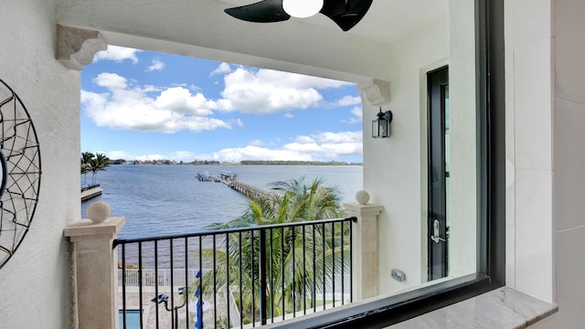 balcony with a water view and ceiling fan