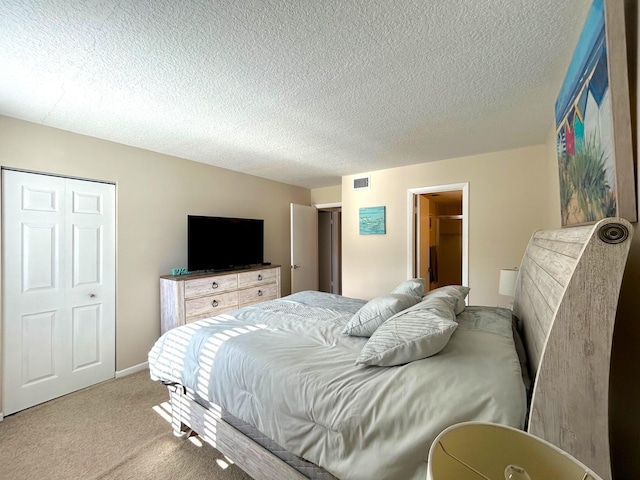 carpeted bedroom with a closet and a textured ceiling