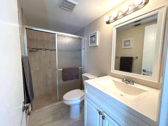 bathroom featuring an enclosed shower, vanity, tile patterned floors, and toilet