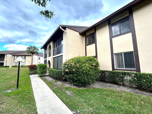 view of side of home with a yard