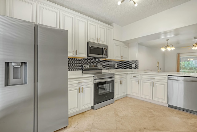 kitchen featuring white cabinetry, appliances with stainless steel finishes, sink, and decorative light fixtures