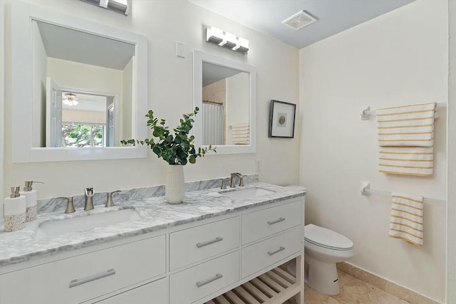 bathroom featuring tile patterned flooring, vanity, and toilet