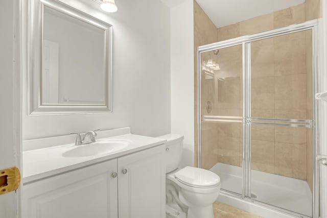 bathroom featuring vanity, an enclosed shower, and toilet