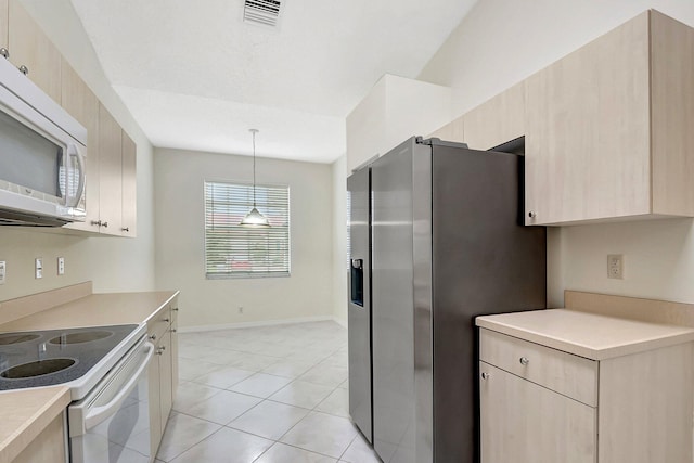 kitchen featuring light brown cabinets, pendant lighting, and white appliances